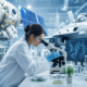 female scientist using a microscope in a lab, surrounded by equipment, monitors displaying dna for specialized life sciences certifications.