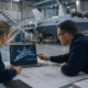 two engineers discussing fighter jet design on a laptop, defence contractor hiring fall.